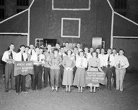 Group of winners at the 1949 Little International Exposition at South Dakota State College. Signs read: Wheat King Little International 1949. Most Outstanding Clothing Entry Little International 1949.