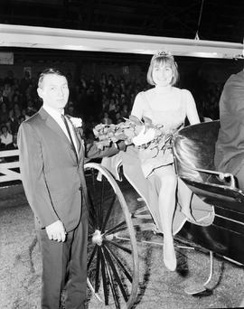 Little International general manager is assisting the Queen from a buggy at the 1965 Little International Exposition at South Dakota State University.
