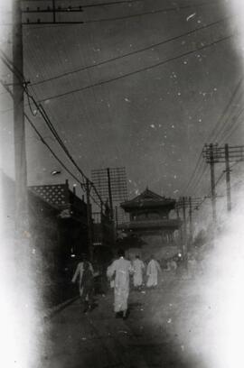 People walking on a street toward a temple in Seoul, Korea in 1924; written in pencil on the back: Seoul, Korea 1924.