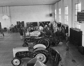 People looking at a display of farm machinery at the 1950 Little International Exposition at South Dakota State College.