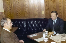 Frank Denholm talking with a constituent in a café.