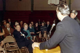 Frank Denholm speaking a group of constituents gathered in a gymnasium.
