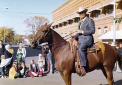 Frank Denholm riding a horse in a parade