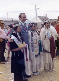 Frank Denholm posing with American Indian dancers at a powwow