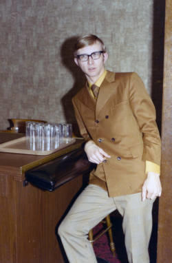 Young man leaning against a bar counter.
