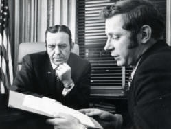 Frank Denholm going over a document with another man