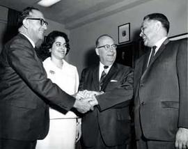 Senator Karl Mundt and Representative Ben Reifel clasp hands with others