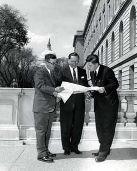Representative Ben Reifel looks at a map with two constituents in Washington, D.C.