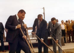 South Dakota Governor Richard Kneip, Congressman Frank Denholm, and others are all holding shovels at a ground breaking ceremony.