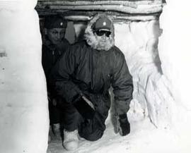 Congressmen emerge from a snow cave prepared for cold weather survival at Fort Richardson, Alaska in 1964