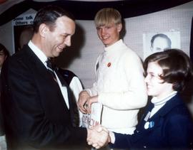 Frank Dehnolm greeting a young supporter at a campaign event. A young man stands behind them.