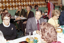 Frank Denholm visiting with constituents in a restaurant.