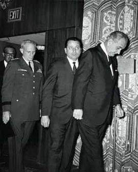 President Lyndon B. Johnson walks out of a room