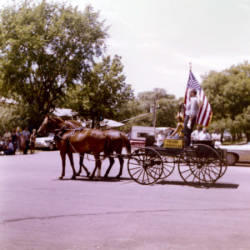 Frank Denholm riding in a horse drawn wagon in the Estelline, South Dakota Fourth of July parade.