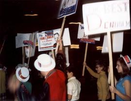 Supporters carrying signs and wearing hats in support of Frank Denholm for Congress during a rally.