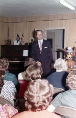 Frank Denholm speaking to a group of people at a campaign event.