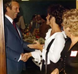 Frank Denholm greeting a woman at an event.