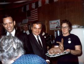 Frank Denholm (left) with group of people. A woman is holding a cake in the shape of a rabbit.