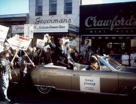 Frank Denholm and his wife, Millie, are riding in a convertible in a parade during his 1968 campaign for Congress.
