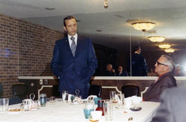 Frank Denholm is speaking to a group in a restaurant.