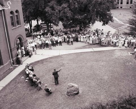 People gathered between the Horticulture Building and the Administration Building for the recognition service for Dr. N.E. Hansen on the campus of South Dakota State College.