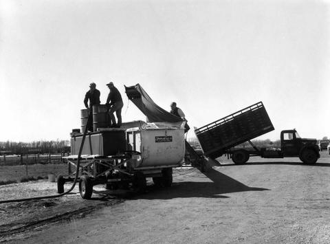 Men coloring sawdust to put on the arena floor for the 1970 Little International exposition at South Dakota State University.