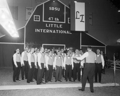 Men choir sings in front of the false barn wall during the 1970 Little International exposition at South Dakota State University.