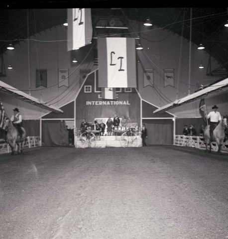 Two men on horseback are the color guard presenting the U.S. flag and the state of South Dakota flag the 1967 Little International Exposition at South Dakota State University.