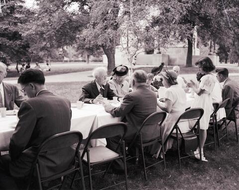 Dr. N.E. Hansen seated at a table visiting with guests at the recognition service his honor on the campus of South Dakota State College.