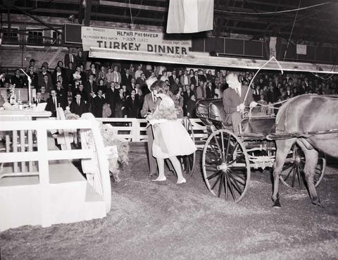 Little International Queen is being escorted from a horse drawn buggy at the 1964 Little International Agricultural Exposition at South Dakota State University.