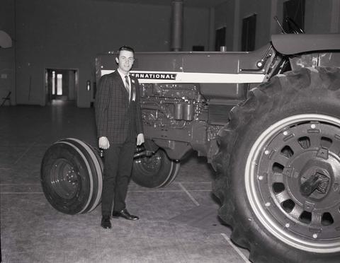 Vendor standing by an International tractor in the machinery show at the 1968 Little International Exposition at South Dakota State University.