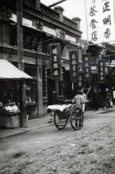 Man pulling a rickshaw down a street in Fushun, Manchuria in northern China; written in pencil on the back: Futachien 1924.