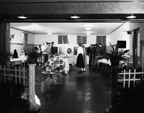 People looking at house plants in the Horticulture booth at the 1949 Little International Exposition at South Dakota State College.