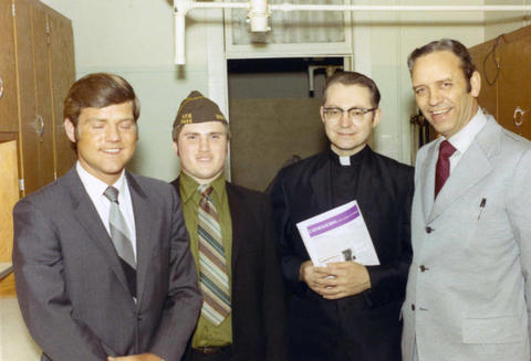 Frank Denholm with a Catholic priest, and member of the VFW, and another man.