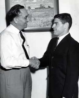 Representative Ben Reifel shaking hands with Bob Dillman, 1961 Deaflympics diving athlete