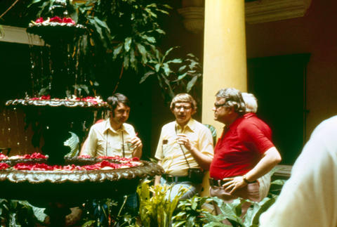 Photographers talking around a fountain in a courtyard in Cuba