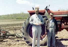 Frank Denholm and a farmer standing next to an International Farmall tractor during Denholm's 1970 campaign.