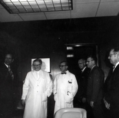 Frank Denholm (left) is with Dr. Lie, Dr. James Chalmers (Acting Chief of Staff), Colin Parkes (Contact Officer), Ralph Heidbrink (Staff Assistant to Director), and Wayne Gass (Center Director) while touring a medical facility.