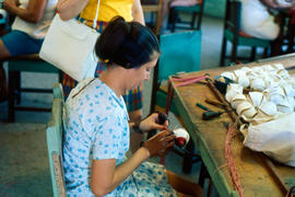 Woman sewing baseballs by hand in a factory in Cuba