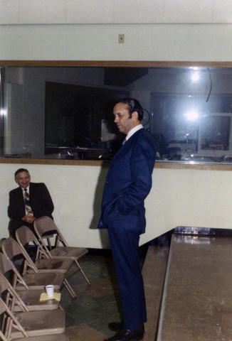 Frank Denholm speaking to a group in a room with a large window.