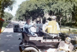 Frank Denholm riding in the South Dakota State University Bummobile during the Hobo Day parade in Brookings, South Dakota