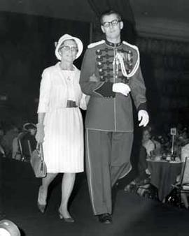 Alice Reifel escorted by a cadet at a brunch with the first lady in 1968
