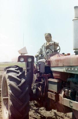 Frank Denholm on a International Farmall tractor plowing a field plowing during his 1970 campaign.