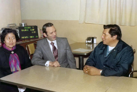 Frank Denholm seated with constituents in a café.