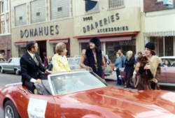 Frank and Millie Denholm riding in a convertible in the Augustana College Vikings Days parade in downtown Sioux Falls, South Dakota.