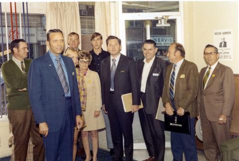 Frank Denholm with a of people in a building.