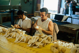 Men sewing baseballs by hand in a factory in Cuba