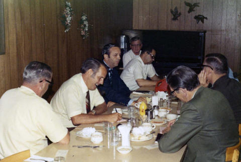 Frank Denholm talking with constituents in a restaurant.