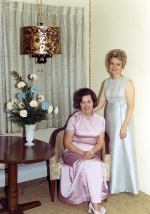 Millie Denholm (standing) and another woman dressed for the post-ceremony ball in celebration of the inauguration of South Dakota Governors Richard Kneip.