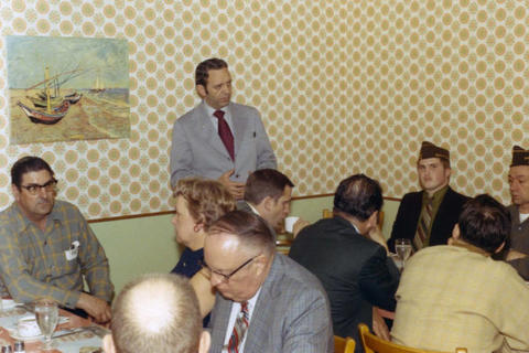 Frank Denholm speaking to constituents in a café.